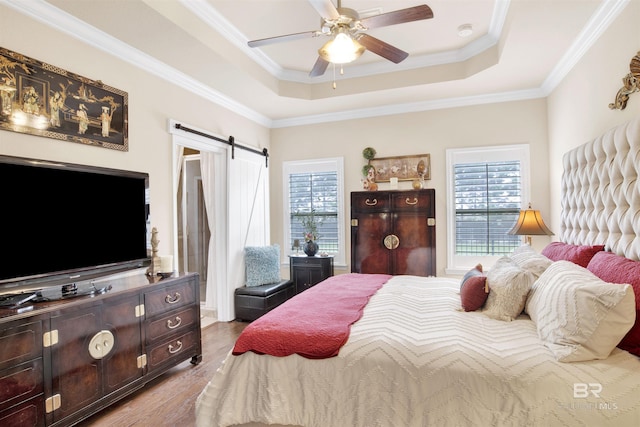 4268 Birkdale St, Gulf Shores, AL 36542 - bedroom featuring multiple windows, a tray ceiling, ornamental molding, wood finished floors, and a barn door