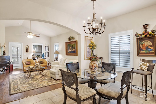 4268 Birkdale St, Gulf Shores, AL 36542 - dining space featuring arched walkways, a chandelier, vaulted ceiling, a ceiling fan, and light tile patterned floors