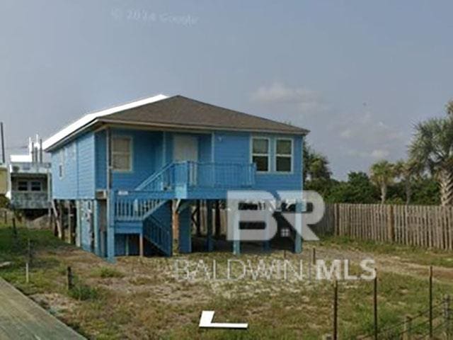 back of house with stairway, a porch, and fence