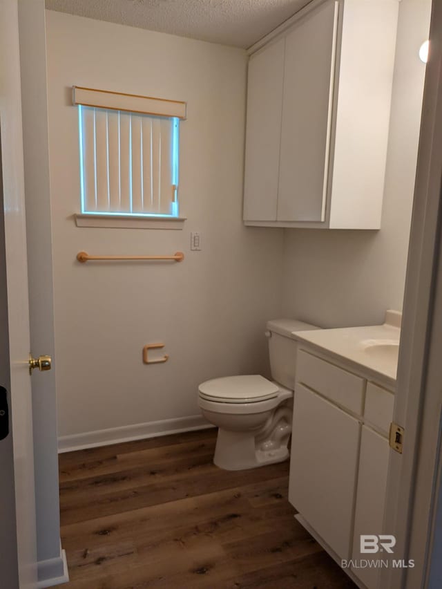 bathroom with vanity, a textured ceiling, toilet, and wood finished floors