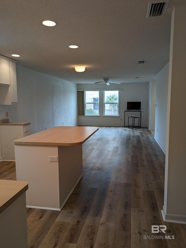 kitchen with visible vents, dark wood-style flooring, ceiling fan, a textured ceiling, and white cabinetry