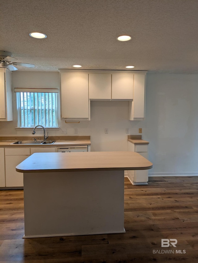 kitchen with a sink, white cabinets, recessed lighting, and a textured ceiling