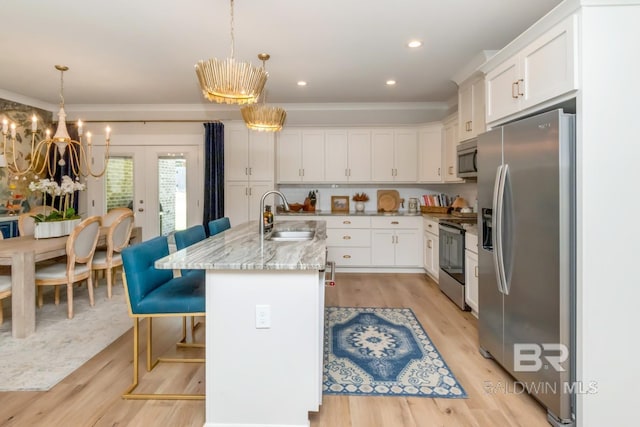 7339 Grissom Dr, Saraland, AL 36571 - kitchen featuring appliances with stainless steel finishes, a sink, white cabinetry, a kitchen breakfast bar, and ornamental molding