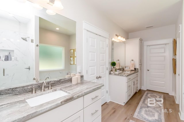 7339 Grissom Dr, Saraland, AL 36571 - bathroom featuring a marble finish shower, wood finished floors, and vanity