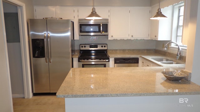 kitchen with white cabinets, decorative light fixtures, sink, and appliances with stainless steel finishes