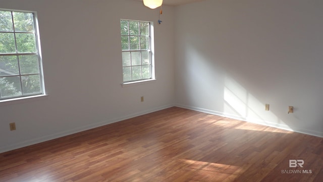 unfurnished room with hardwood / wood-style flooring