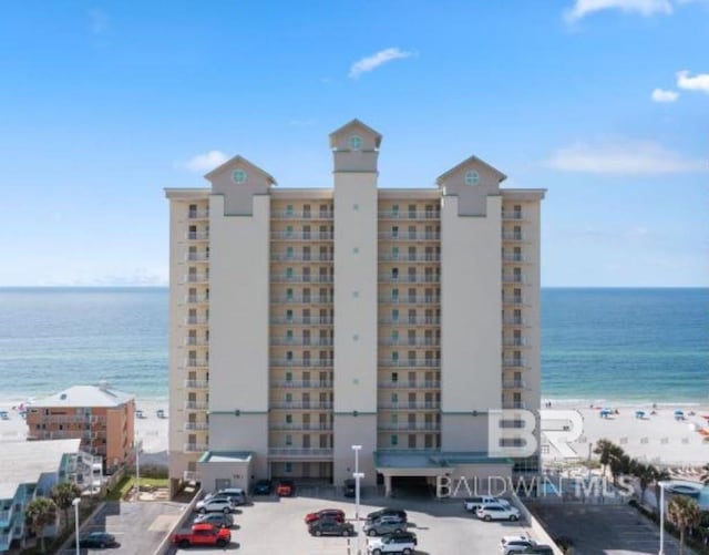 view of building exterior featuring a water view and uncovered parking