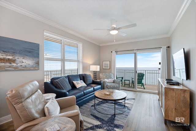 living area featuring ornamental molding, baseboards, a ceiling fan, and wood finished floors