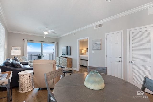 dining area featuring wood finished floors, baseboards, visible vents, ceiling fan, and ornamental molding