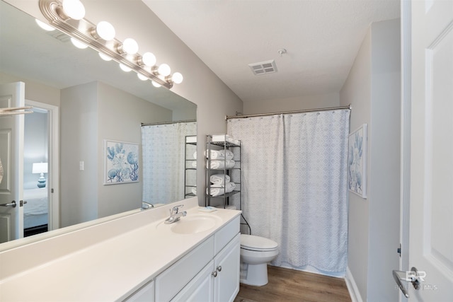 full bathroom featuring visible vents, toilet, curtained shower, wood finished floors, and vanity