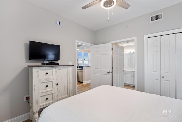 bedroom with baseboards, visible vents, light wood-style flooring, a closet, and connected bathroom