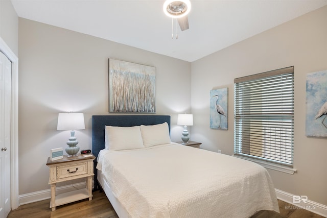 bedroom featuring wood finished floors, baseboards, and ceiling fan