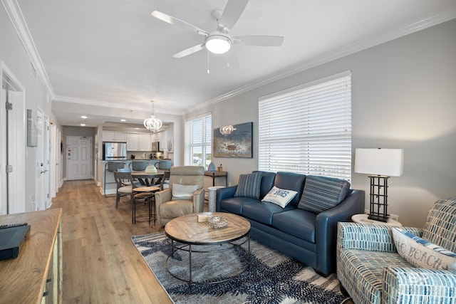 living area featuring crown molding, a ceiling fan, light wood-type flooring, and visible vents