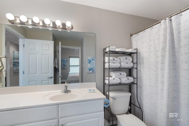 ensuite bathroom with vanity, ensuite bath, and toilet