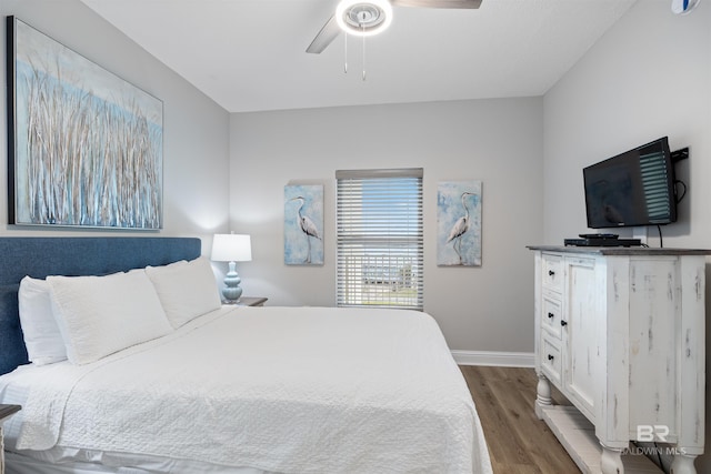 bedroom featuring dark wood finished floors, a ceiling fan, and baseboards