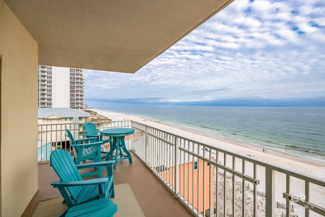 balcony featuring a water view and a beach view