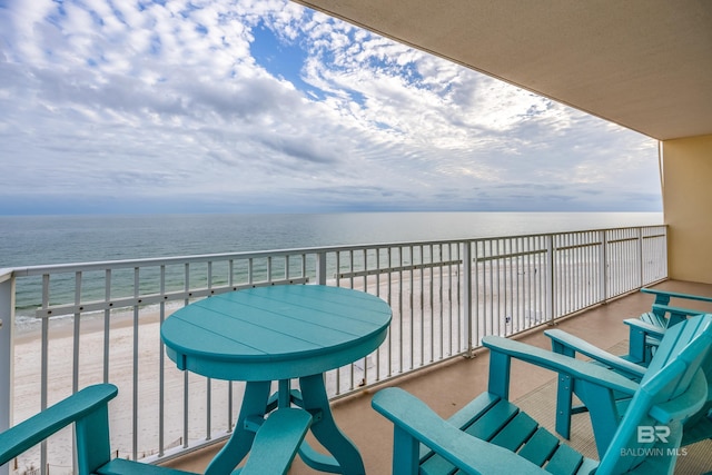 balcony featuring a view of the beach and a water view