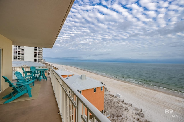 balcony featuring a view of the beach and a water view