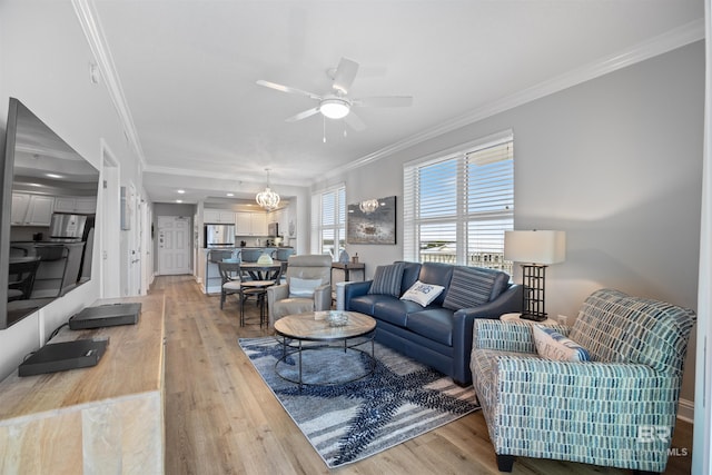 living room featuring light wood-style flooring, a ceiling fan, and ornamental molding