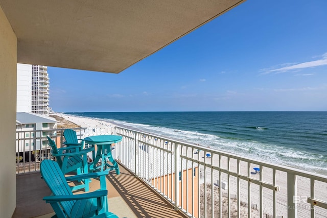 balcony with a water view and a view of the beach