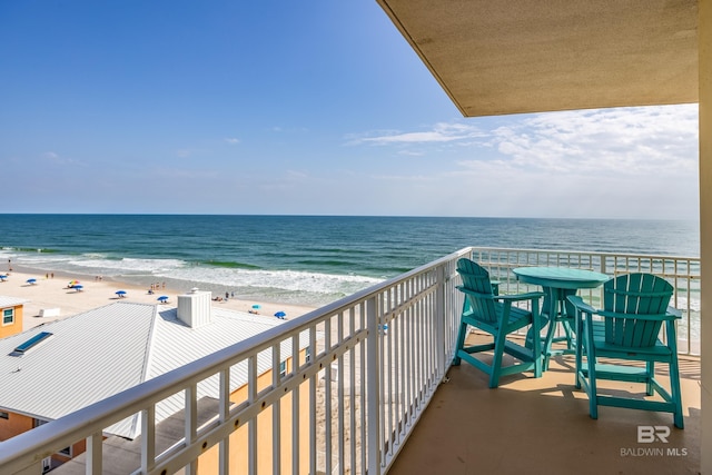 balcony with a water view and a beach view