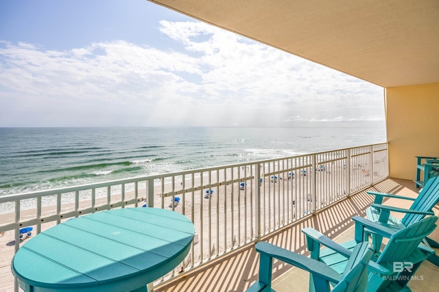 balcony featuring a water view and a view of the beach