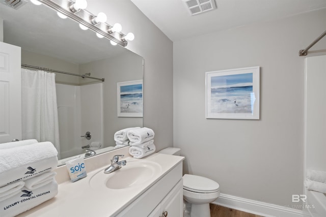 bathroom featuring vanity, toilet, baseboards, and visible vents