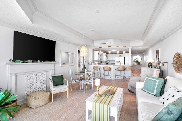 living room featuring a tray ceiling, crown molding, a textured ceiling, and hardwood / wood-style flooring