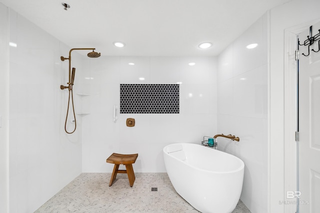 bathroom with tile walls and shower with separate bathtub