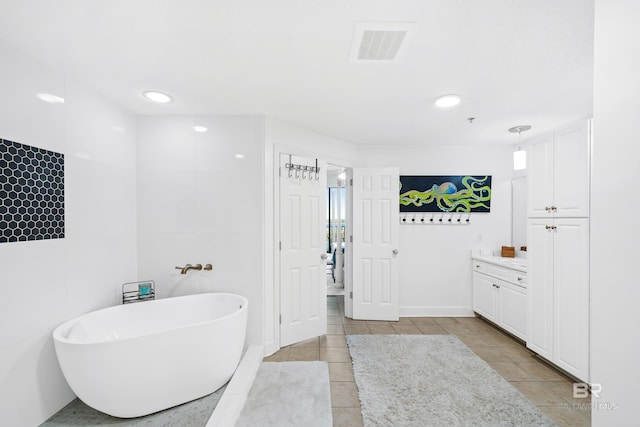 bathroom featuring tile patterned floors, a bathtub, and vanity