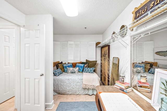 bedroom with light tile patterned floors and a textured ceiling