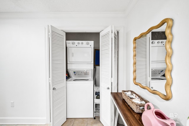 laundry area with a textured ceiling, crown molding, and stacked washer / dryer