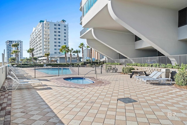 view of swimming pool featuring a patio and a hot tub