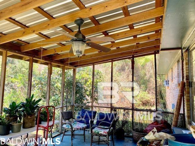 unfurnished sunroom with ceiling fan