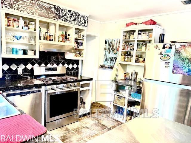 kitchen with tasteful backsplash and appliances with stainless steel finishes