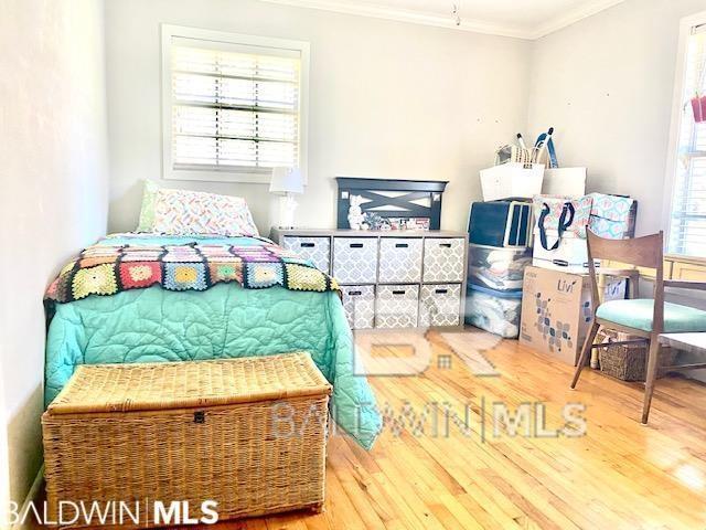 bedroom featuring hardwood / wood-style flooring and ornamental molding