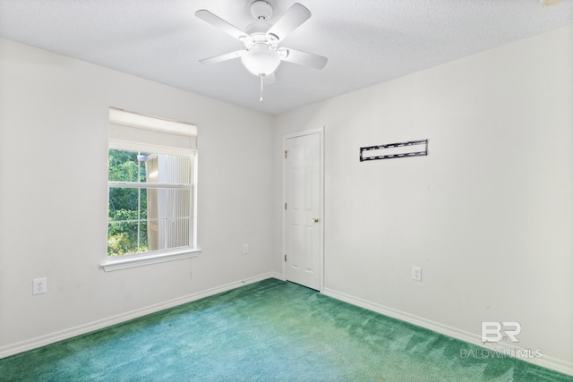 carpeted spare room with a textured ceiling and ceiling fan