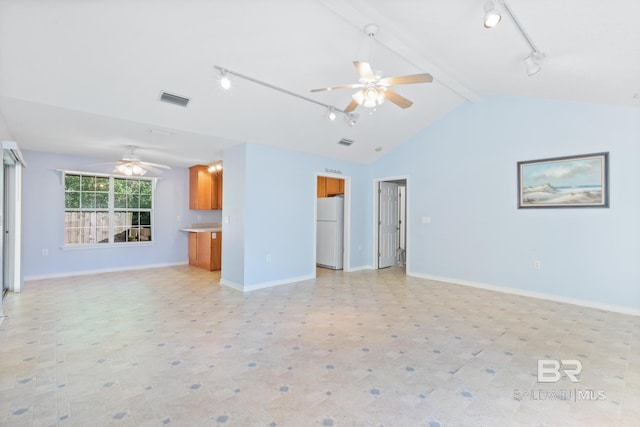 unfurnished living room with ceiling fan, vaulted ceiling with beams, and track lighting