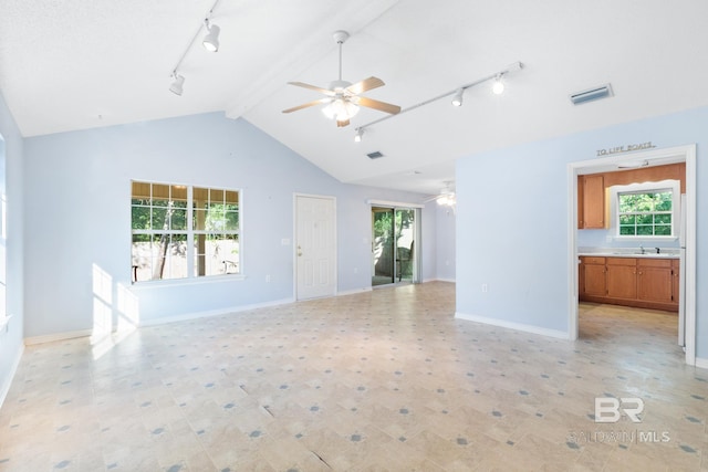 unfurnished living room featuring rail lighting, sink, lofted ceiling with beams, and ceiling fan