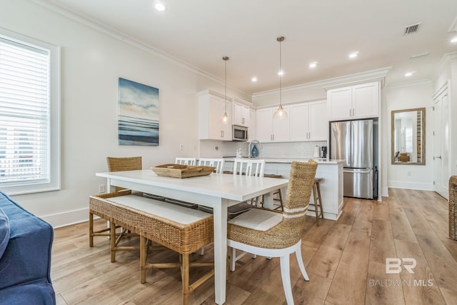 1050 W Beach Blvd Unit E, Gulf Shores, AL 36542 - dining space featuring light wood finished floors, healthy amount of natural light, ornamental molding, and recessed lighting