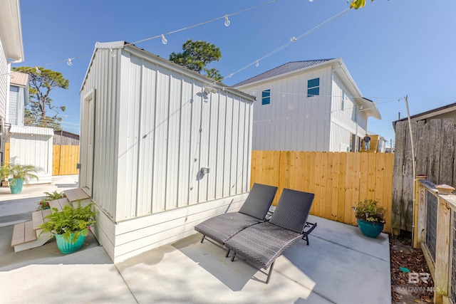 view of patio / terrace with fence and an outdoor structure