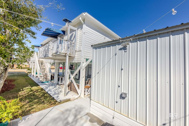 view of property exterior featuring stairs and a patio