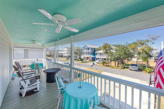 wooden deck with a residential view and a ceiling fan