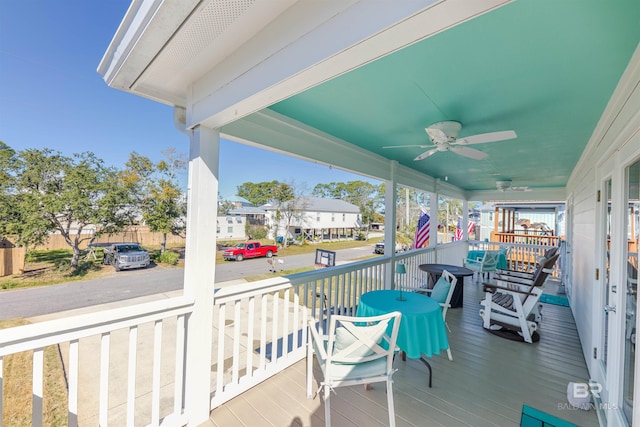 wooden deck with covered porch and a ceiling fan