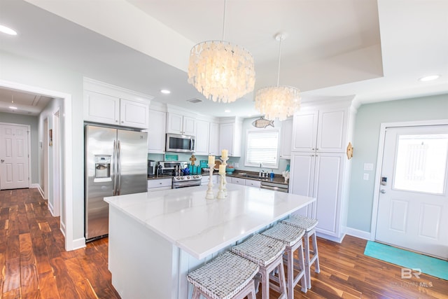 kitchen featuring stainless steel appliances, recessed lighting, dark wood-type flooring, white cabinetry, and a chandelier