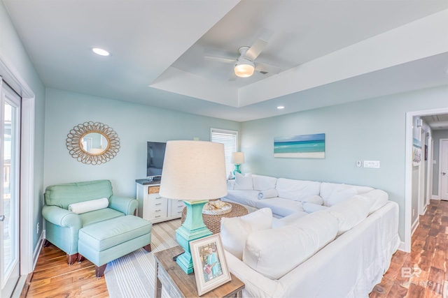 living room with light wood-type flooring, a ceiling fan, and recessed lighting