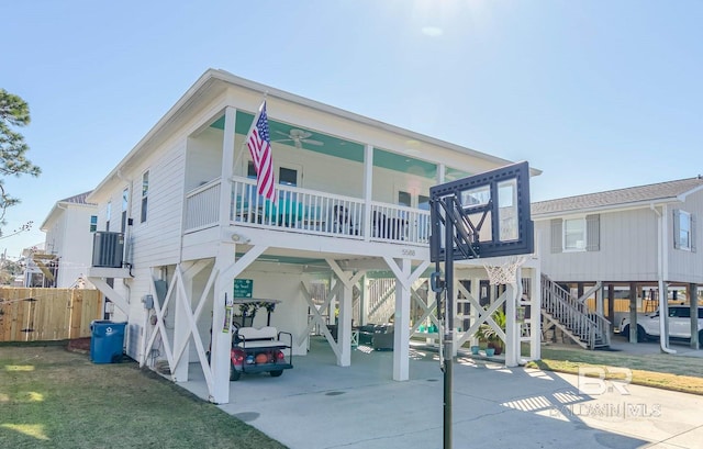 view of front of house featuring driveway, stairs, fence, and a carport