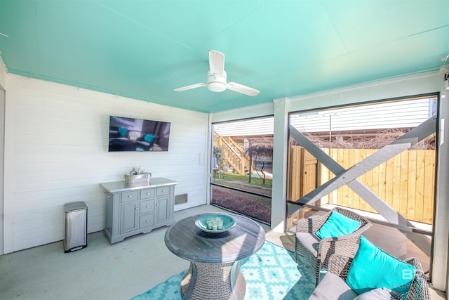 sunroom / solarium featuring a ceiling fan