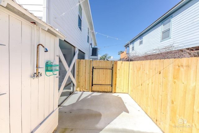 view of patio with a gate, central AC, and fence