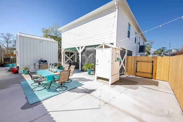 view of patio with a shed, a gate, and an outbuilding